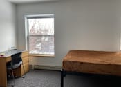 Thumbnail 5 of 15 - a bedroom with a bed and a desk and a window